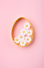 Easter Eggs with Sweets and Spring Flowers on Pink Background