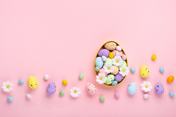 Fototapeta na wymiar Easter Eggs with Sweets and Spring Flowers on Pink Background