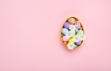 Easter Eggs with Sweets and Spring Flowers on Pink Background