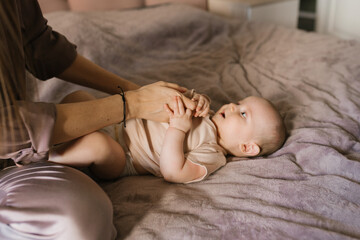 A mother dresses or changes her cute sweet newborn baby