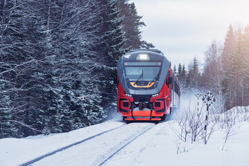 Passenger train moves fast at winter day.