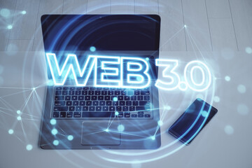 Web 3.0 - a new generation of the Internet, using blockchain and AI, modern technologies IoT. Close up of laptop and smartphone with hologram on desktop and blurry background. Double exposure.