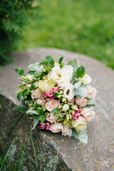 Wedding beautiful rustic bouquet of flowers on the old stone