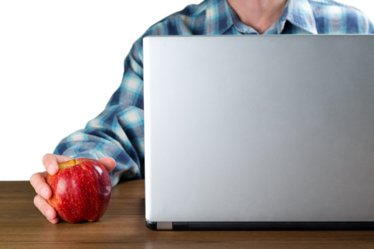 Portrait of young man holding red apple using laptop isolated on white background
