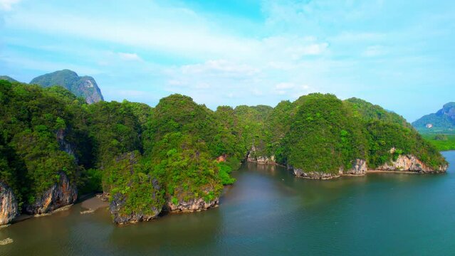 The drone captured a stunning landscape of limestone mountains covered in lush forest, meeting the estuary where mangrove forests thrive, creating a unique ecosystem in Thailand. 4K UHD
