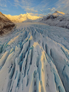 Sunset light viewed over Svinafelljokull Glacier in Iceland, vertical panorama shot taken from drone.