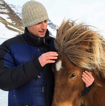 Man stroking friendly Icelandic horse, Iceland