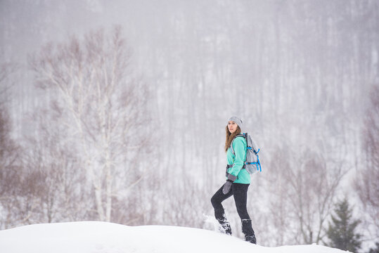 Woman walking in snow in forest
