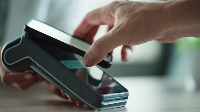 Video of female customer using her credit card to make payment with electronic reader in a shop.