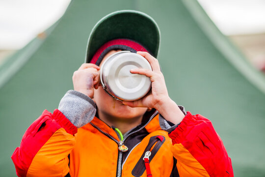 Boy drinking from steel mug