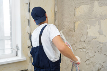 The process of applying plaster to walls inside a building by machine.