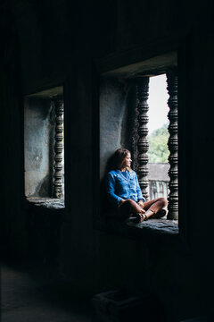 A girl is looking in the distance in a Cambodian temple