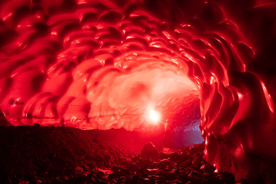 Man with flare in snow cave, Mutnovsky, Kamchatka Peninsula, Russia