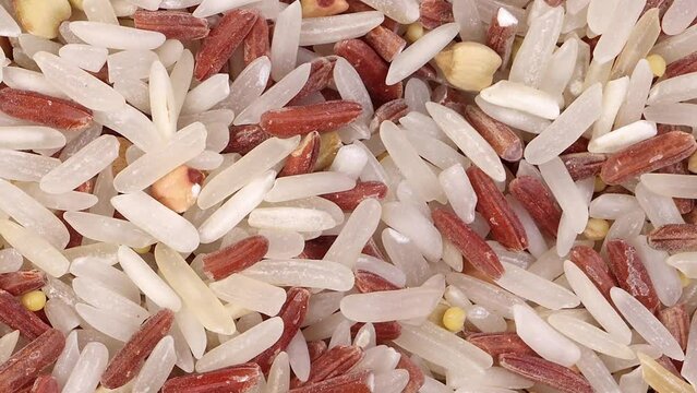 Mixed low glycaemic index healthy rice grain basmati millet buckwheat red rice heap on white background top view pan zoom out 