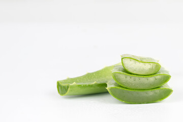 Fresh aloe vera leaves and slices isolate against white background for health and beauty products.