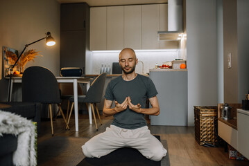 A man meditates at home in an apartment. Breathing practices