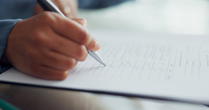 Hands, pen and writing in checklist, survey or FAQ questionnaire on table or desk at the office. Hand in write, tick or business contract or form for documentation, paperwork or feedback at workplace