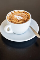 Obraz premium Cappuccino con un disegno di un cuore sulla schiuma servito in un bar per colazione