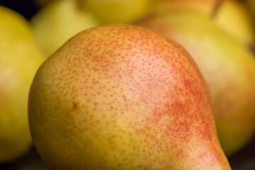 A yellow ripe pear with a red side on the table