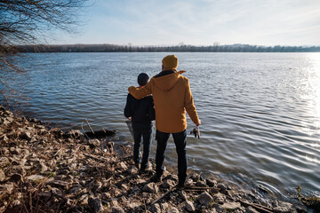 Fototapeta na wymiar Father and son are ready for fishing on winter day. Freshwater fishing.