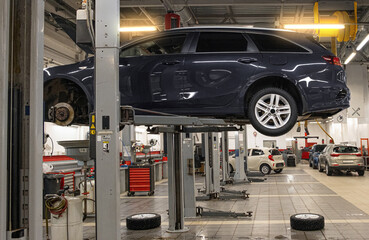 Car on a lift in a service center for preventive maintenance and system checks
