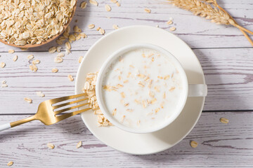 A cup of lean oatmeal milk  porridge on wooden table.healthy breakfast