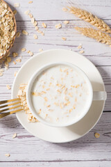 A cup of lean oatmeal milk  porridge on wooden table.healthy breakfast