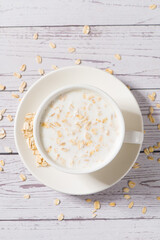 A cup of lean oatmeal milk  porridge on wooden table.healthy breakfast