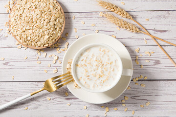 A cup of lean oatmeal milk  porridge on wooden table.healthy breakfast