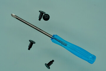 Screwdriver with a blue handle and black screws on a blue back