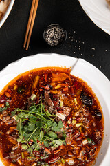 Portion of chinese szechuan beef dish on black wooden background