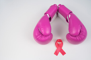 Pink boxing gloves and a pink silk ribbon on a white background. Breast cancer concept. 