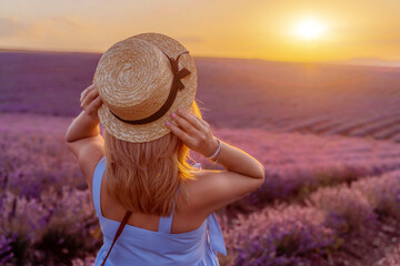 Woman lavender field sunset. Romantic woman walks through the lavender fields. illuminated by...