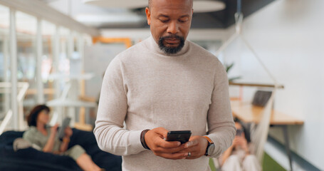 Businessman in office walking, typing on smartphone and greeting people at creative startup. Communication, technology and black man on walk at business checking phone for social media, email or text