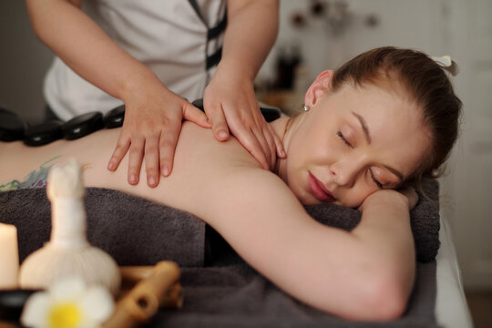 Masseuse applying gentle, sustained pressure to myofascial connective tissue to release muscle tightness