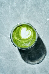 Green matcha latte on plant milk on concrete background. Healthy Eating