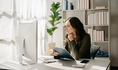 Obraz na płótnie Canvas Confident business expert attractive smiling young woman typing laptop ang holding digital tablet on desk in creative home office.