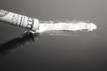 Snorting cocaine, white powder line, rolled up dollar bill, black background