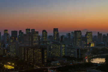Sunset in Tokyo. View of the city center with modern skyscrapers and the iconic Mount Fuji