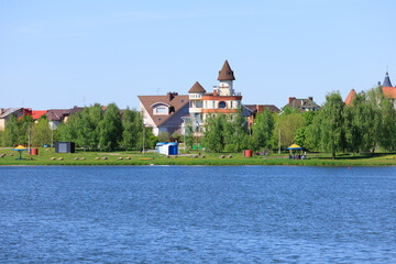Naklejka na ściany i meble Buildings and houses standing on the shore of a lake, river or sea. 