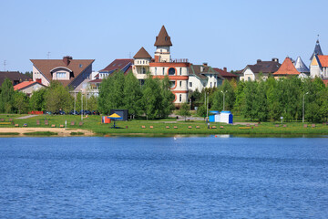 Fototapeta premium Buildings and houses standing on the shore of a lake, river or sea. 