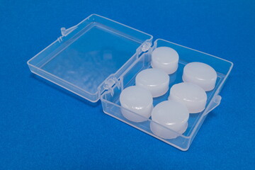 Silicone ear plugs for human ears on blue background