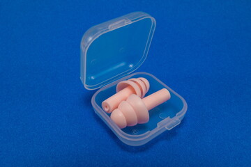 Silicone ear plugs for human ears on blue background