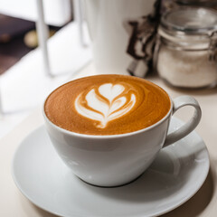 Delicious cappuccino with a beautiful foam in a white cup . Stylish concept of beautiful coffee under the size of Instagram.