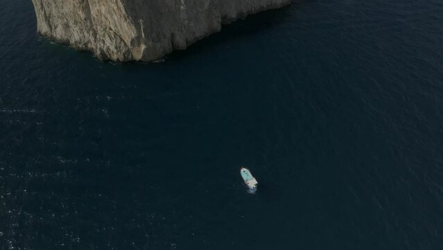 Aerial view of sailing boat cruising near the Faraglioni rock formation off Capri Island, Naples, Italy.