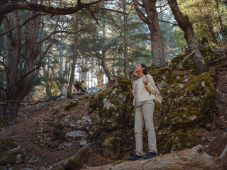 Obraz premium asian woman enjoys being in nature, beautiful forest in mountains. embracing fresh air and engaging in outdoor activities. Friluftsliv concept means spending as much time outdoors as possible