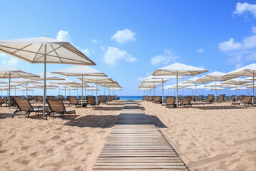 Beautiful tropical  scenery. Sun beds,loungers, umbrella. White sand. Sea. Resort hotel. Rows of...