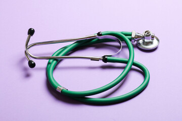 Top view of green medical stethoscope on colorful background with copy space. Medicine equipment concept