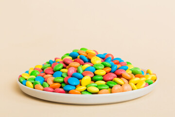 Multicolored candies in a bowl on a colored background. birthday and holiday concept. Top view with copy space