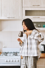Tasty flavor. Morning begins with fresh coffee. Asian woman sniffs freshly brewed coffee in cevze - 576633575